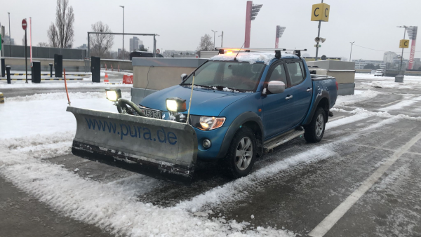 Vozidlo STONE TRADE s prednou radlicou a zadným sypačom LEHNER POLARO pri čistení zasneženého parkoviska v Bratislave.