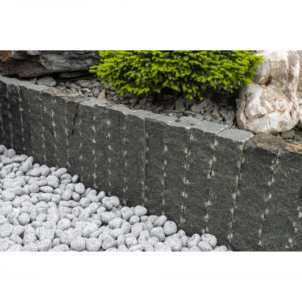 Ukážka použitia tmavosivej žulovej palisády Z95 od StoneTrade na vytvorenie vyvýšeného záhona v kombinácii s bielym okrasným kamenivom.