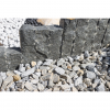 Tmavosivá žulová palisáda z línie Nero Z95 od StoneTrade použitá ako dekoratívne olemovanie solitérneho kamenného kaktusu v okrasnom záhone.