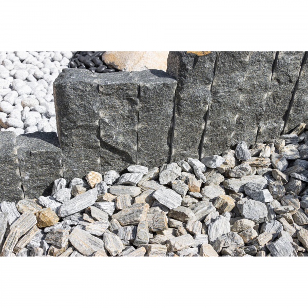 Tmavosivá žulová palisáda z línie Nero Z95 od StoneTrade použitá ako dekoratívne olemovanie solitérneho kamenného kaktusu v okrasnom záhone.