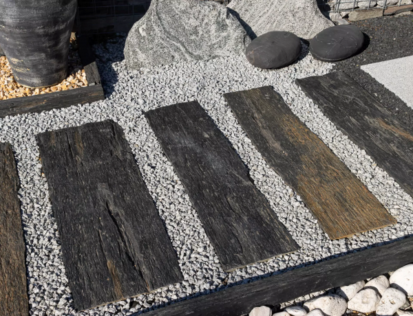 Žulová drť Bianco Nero Z81 od STONE TRADE použitá medzi kamennými nášľapmi v záhrade