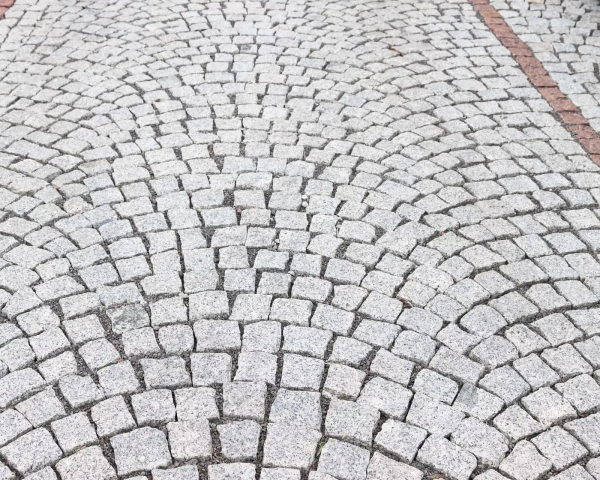Detail sekaných kamenných kociek Žula Bianco Nero od STONE TRADE ukladaných do oblúkového vzoru